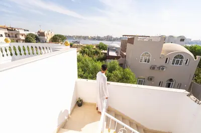 a man standing on a balcony looking out at the city at Home of ISIS in Luxor
