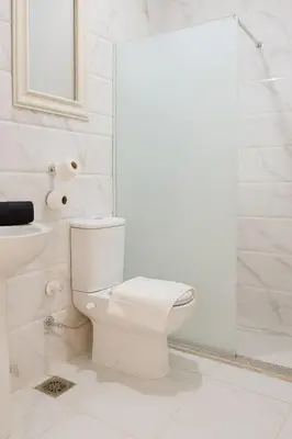 a white bathroom with a toilet and a sink at stylish cozy one bedroom apartment in Hurghada
