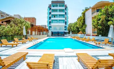 a swimming pool with chairs and a building at stylish cozy one bedroom apartment in Hurghada