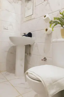 a white bathroom with a toilet and a sink at stylish cozy one bedroom apartment in Hurghada
