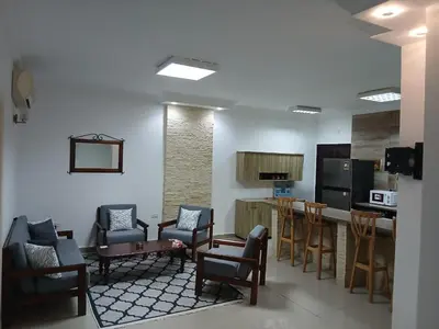 a living room with chairs and a kitchen with a counter at Sea View 2 Bedroom Apartment in El-Hadaba in Hurghada