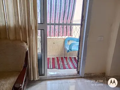 an open door to a balcony with a chair outside at بيت فرح in Nag` el-Fuqâhi