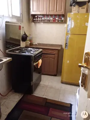 a kitchen with a stove and a yellow refrigerator at بيت فرح in Nag` el-Fuqâhi