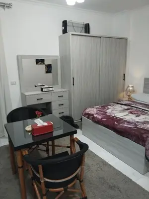 a bedroom with a bed and a desk with a table at Hurghada neighborhoods in Hurghada