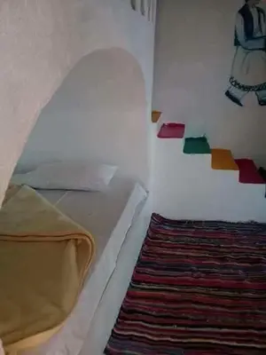 a bedroom with a bed and a colorful wall at فندق اجيليكا in Aswân Reservoir Colony