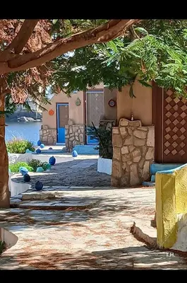 a courtyard with a building with a stone wall at فندق اجيليكا in Aswân Reservoir Colony