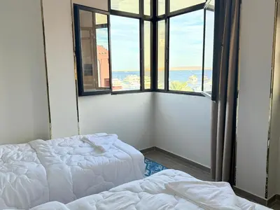 a room with two beds and a window with a view at VERO Residence in Banī Ghālib