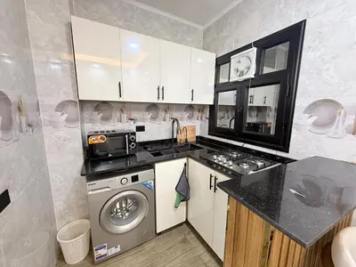 a kitchen with a washer and dryer in it at VERO Residence in Banī Ghālib