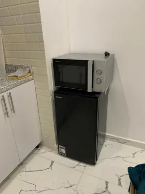 a microwave sitting on top of a small refrigerator at Sea Light Arabia on the beach in Hurghada