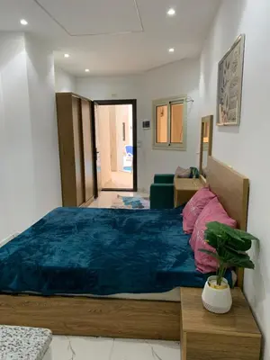 a bedroom with a large bed with a blue blanket at Sea Light Arabia on the beach in Hurghada