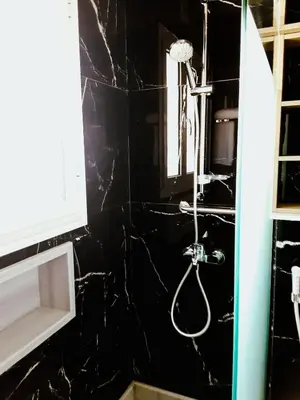 a shower in a bathroom with a black wall at VIP villa heated pool & Spa & fully entertained in Hurghada