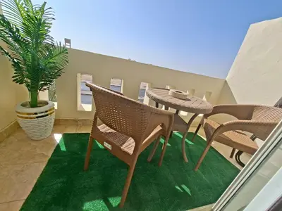 a balcony with a table and chairs and a plant at Hurghada Resort in Hurghada