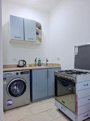 a kitchen with a stove and a washing machine at Hurghada Resort in Hurghada