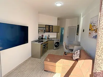 a living room with a couch and a kitchen at Aqua palms in Hurghada