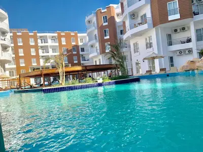 a large swimming pool in front of some buildings at Aqua palms in Hurghada