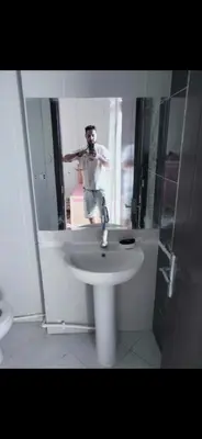 a man standing in front of a sink in a bathroom at Al helal in Hurghada