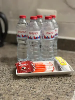 a tray with three bottles of water and a pack of cigarettes at Luxe Nest Luxor Serviced Apartments 202 in Luxor