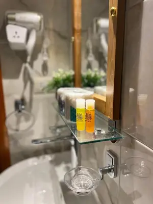 a bathroom sink with two glasses on a glass shelf at Luxe Nest Luxor Serviced Apartments 202 in Luxor
