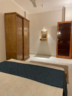 a bedroom with a bed and a wooden cabinet at Luxe Nest Luxor Serviced Apartments 202 in Luxor