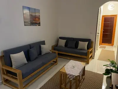 a living room with two blue couches and a table at Luxe Nest Luxor Serviced Apartments 202 in Luxor