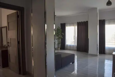 a living room with a couch and two windows at Quiet Corner Apartment in Luxor