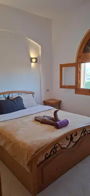 a bedroom with a large bed with a wooden frame at El Gouna Upper nubia in Hurghada