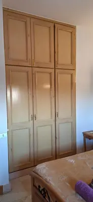 a large wooden cabinet in a room with a table at El Gouna Upper nubia in Hurghada