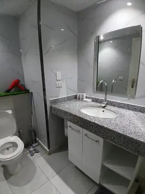 a bathroom with a sink and a toilet and a mirror at Amazing studio in Scandic resort in Hurghada