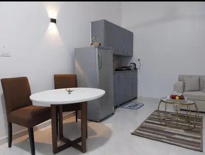 a kitchen with a white table and a refrigerator at Desert Daisy in Luxor