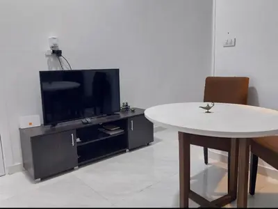 a living room with a table and a tv at Desert Daisy in Luxor