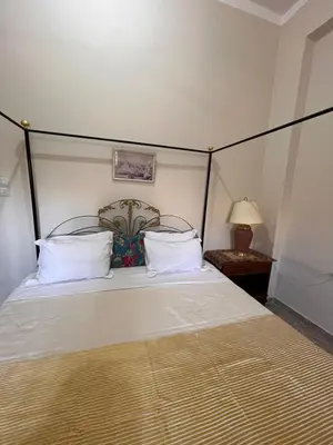 a bedroom with a bed with white sheets and pillows at Abdalla's House in Al Aqālitah