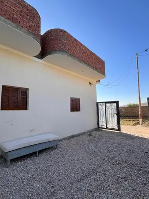a white building with a bench in front of it at Abdalla's House in Al Aqālitah