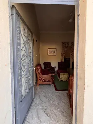 an entrance to a living room with chairs and tables at Abdalla's House in Al Aqālitah