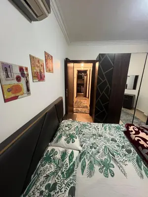 a bedroom with a bed with a green and white comforter at الكوثر المنتجع البريطاني البريتش ريزورت in Hurghada