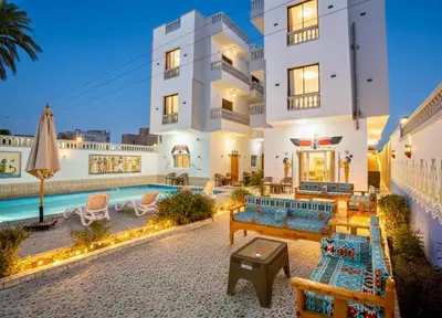 a villa with a swimming pool at night at Astralis Hotel in Al Aqālitah