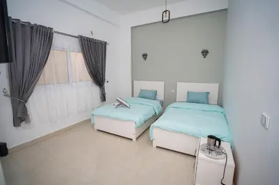 a bedroom with two beds and a window at Astralis Hotel in Al Aqālitah