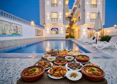 a buffet of food next to a swimming pool at Astralis Hotel in Al Aqālitah