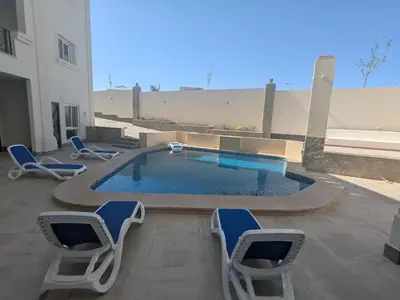 a swimming pool with lounge chairs and a swimming pool at Magawish Studio #3 with pool view in Hurghada