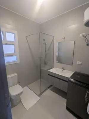 a bathroom with a toilet and a shower and a sink at Magawish Studio #3 with pool view in Hurghada