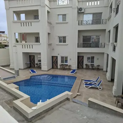 an apartment with a swimming pool and a building at Magawish Studio with Pool in Hurghada