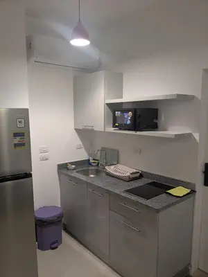 a kitchen with a sink and a microwave at Magawish Studio with Pool in Hurghada