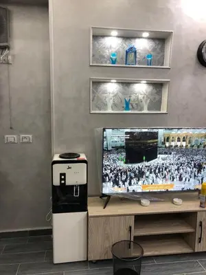 a room with a television and a table with a machine at West Side Village in Hurghada