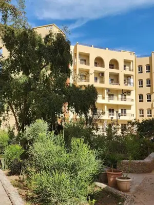 a large building with plants in front of it at West Side Village in Hurghada