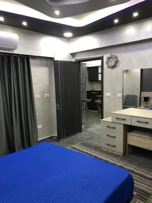 a bedroom with a blue bed and a desk at West Side Village in Hurghada