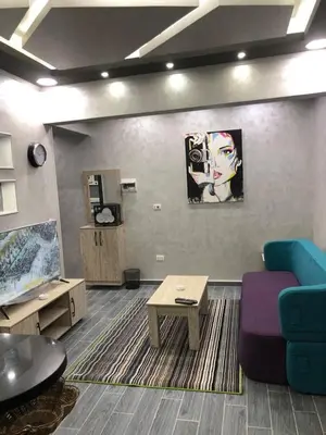 a living room with a blue couch and a table at West Side Village in Hurghada