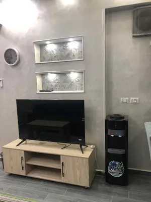 a living room with a flat screen tv on a wall at West Side Village in Hurghada