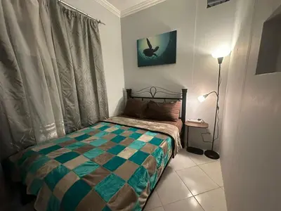 a small bedroom with a bed and a lamp at Desert Pearl Lux in Hurghada
