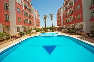 a swimming pool in the middle of a courtyard with buildings at Desert Pearl Lux in Hurghada