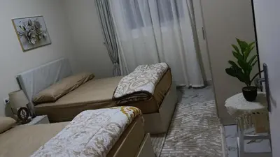 a small room with two beds and a plant at Sea view Hotel Apartment in center in Hurghada