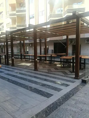 a pavilion with wooden tables in front of a building at Sea view Hotel Apartment in center in Hurghada